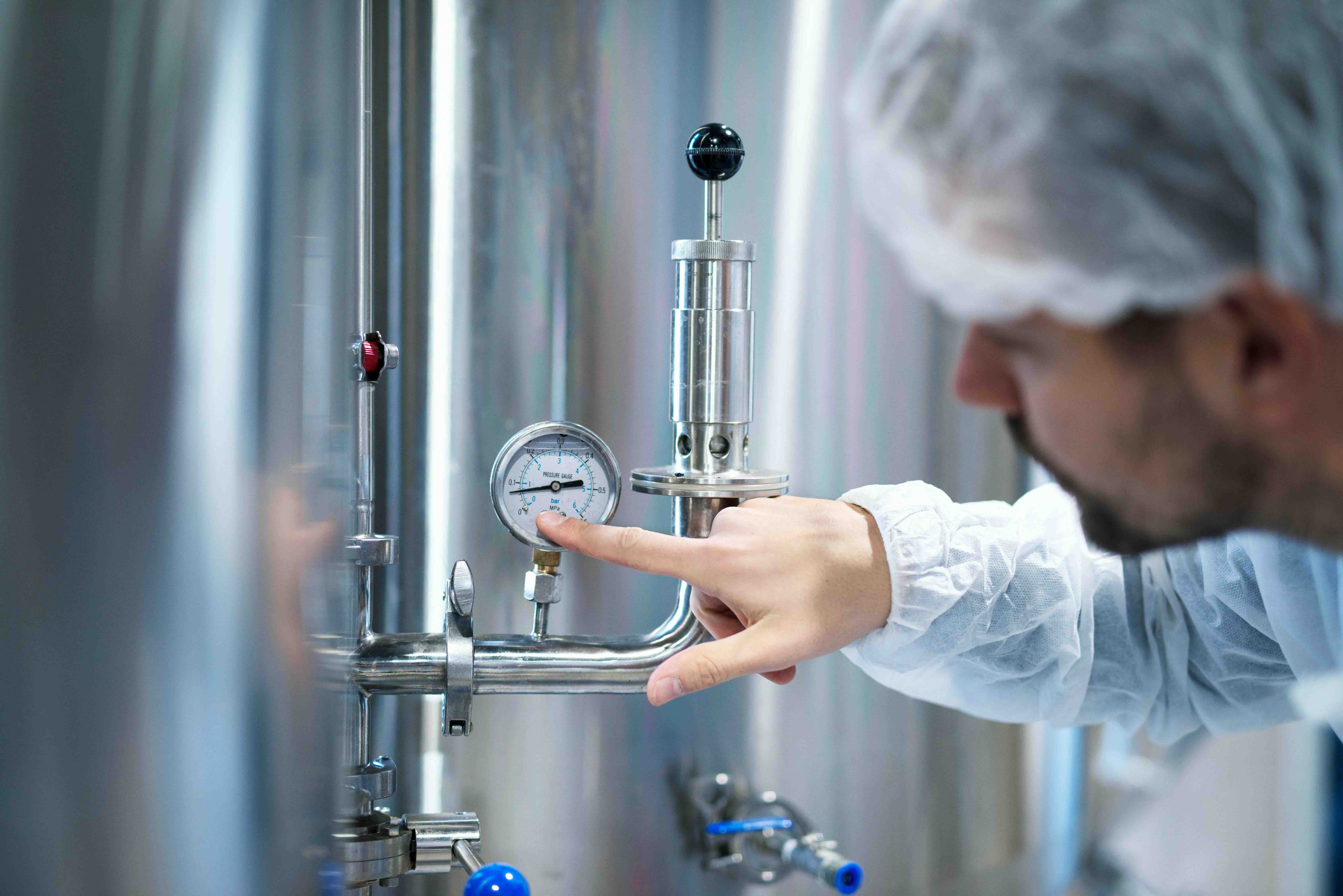 technologist-white-protective-suit-checking-pressure-pressure-gauge-industrial-machine-factory